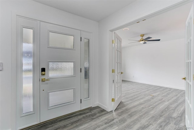 entrance foyer with a ceiling fan, baseboards, and wood finished floors