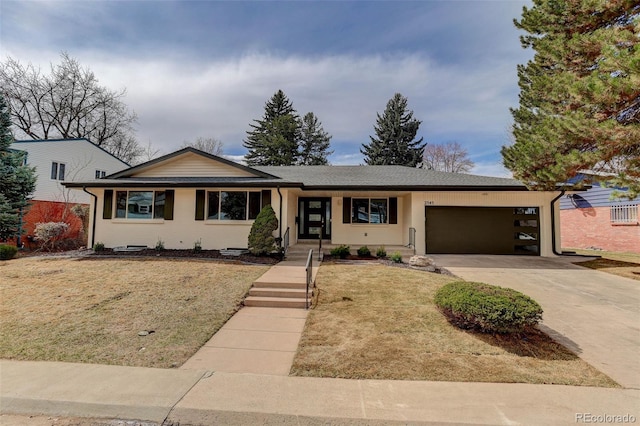 ranch-style house featuring concrete driveway, a garage, and a front yard