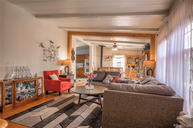 living room with hardwood / wood-style floors, plenty of natural light, and lofted ceiling with beams