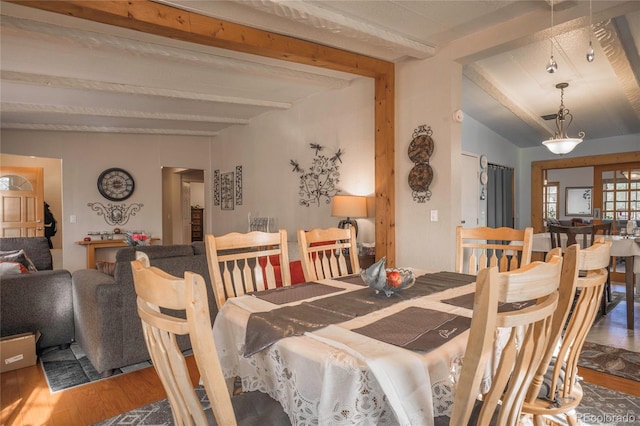 dining room featuring vaulted ceiling with beams and hardwood / wood-style flooring