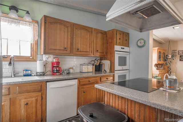 kitchen featuring premium range hood, sink, backsplash, and white appliances