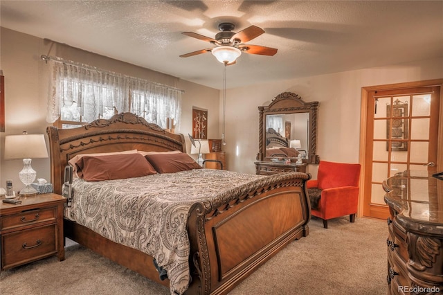 carpeted bedroom with ceiling fan and a textured ceiling