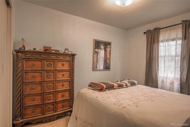 carpeted bedroom featuring a textured ceiling