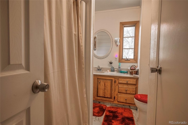 bathroom with vanity, ornamental molding, and toilet