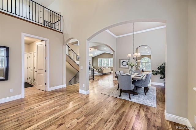 940 Kearney St, Denver, CO 80220 - dining room with wood finished floors, a high ceiling, stairs, arched walkways, and crown molding