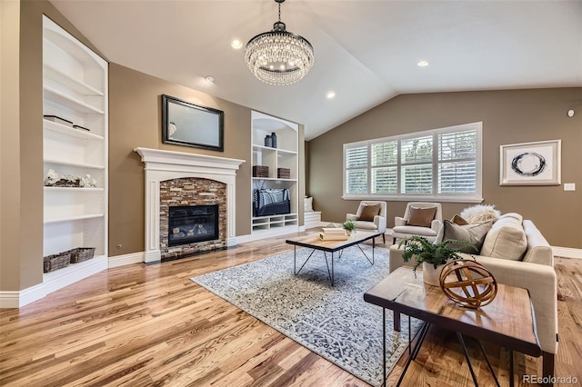 940 Kearney St, Denver, CO 80220 - living room with built in features, wood finished floors, a fireplace, a chandelier, and lofted ceiling