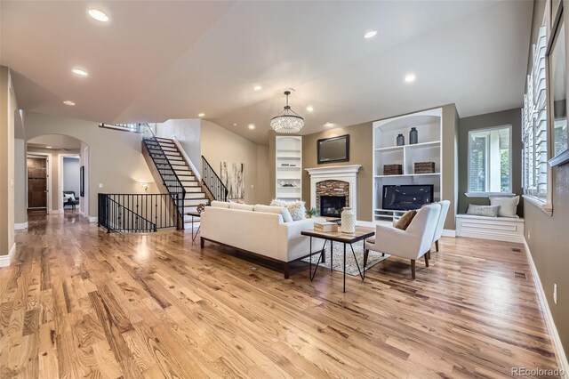 940 Kearney St, Denver, CO 80220 - living area featuring wood finished floors, stairs, arched walkways, a stone fireplace, and recessed lighting