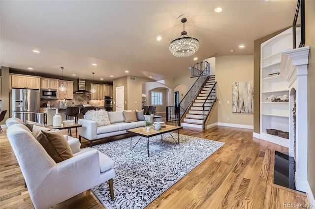 940 Kearney St, Denver, CO 80220 - living area with arched walkways, stairs, light wood-style flooring, recessed lighting, and a chandelier