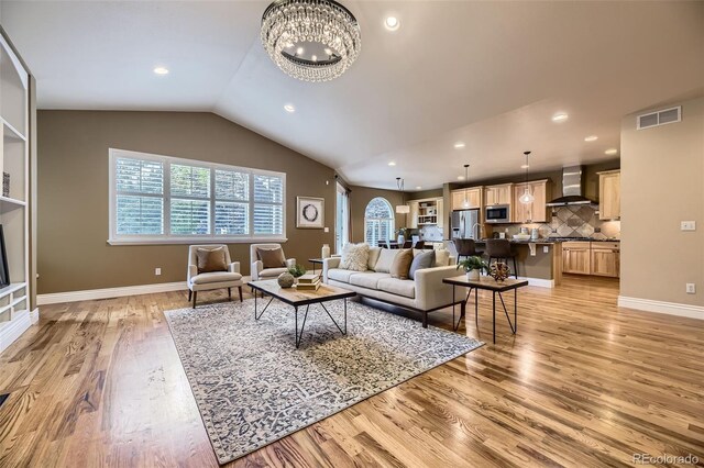940 Kearney St, Denver, CO 80220 - living area with light wood-type flooring, vaulted ceiling, a chandelier, and recessed lighting