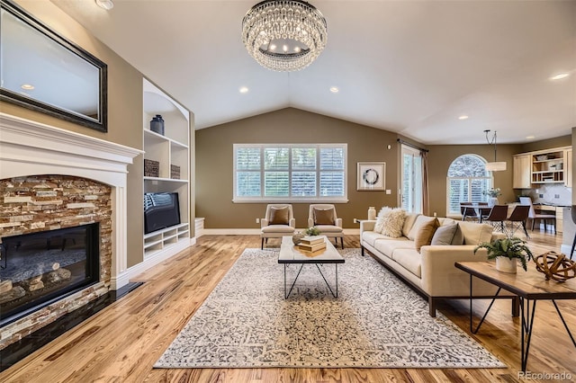 940 Kearney St, Denver, CO 80220 - living area featuring a stone fireplace, a chandelier, wood finished floors, vaulted ceiling, and built in shelves