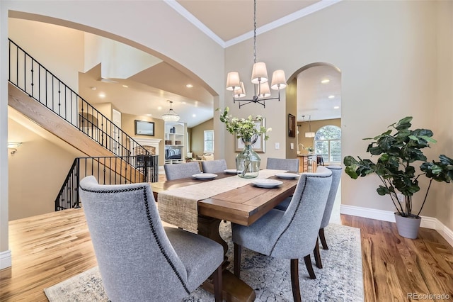 940 Kearney St, Denver, CO 80220 - dining space with arched walkways, a chandelier, crown molding, wood finished floors, and a high ceiling
