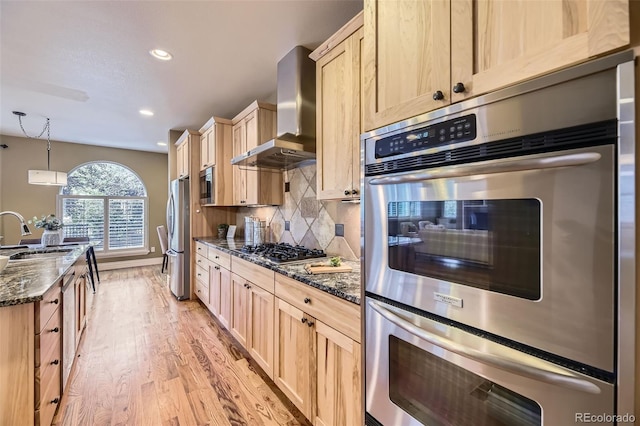 940 Kearney St, Denver, CO 80220 - kitchen featuring wall chimney exhaust hood, light brown cabinets, stainless steel appliances, light wood-type flooring, and recessed lighting