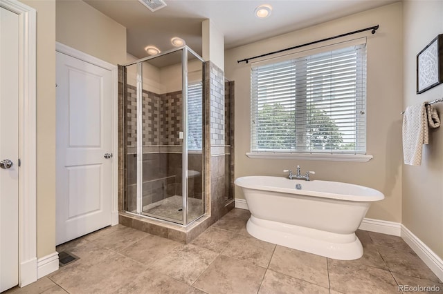 940 Kearney St, Denver, CO 80220 - full bath featuring a stall shower, a freestanding tub, and tile patterned floors