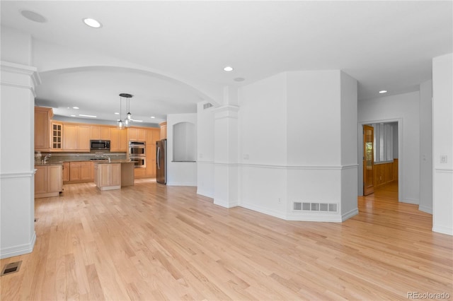 1172 S Steele St, Denver, CO 80210 - unfurnished living room with light wood finished floors, recessed lighting, and arched walkways
