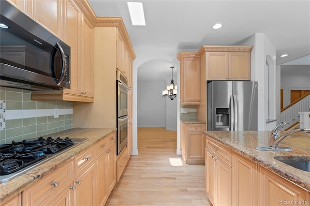 1172 S Steele St, Denver, CO 80210 - kitchen with appliances with stainless steel finishes, light wood-style floors, light brown cabinetry, a chandelier, and recessed lighting