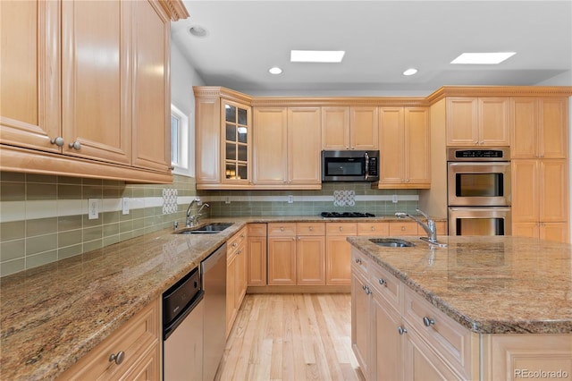 1172 S Steele St, Denver, CO 80210 - kitchen with stainless steel appliances, light brown cabinets, light wood-type flooring, glass insert cabinets, and recessed lighting