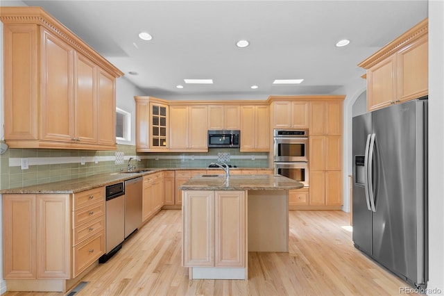 1172 S Steele St, Denver, CO 80210 - kitchen featuring stainless steel appliances, light brown cabinetry, light stone countertops, light wood-style floors, and recessed lighting