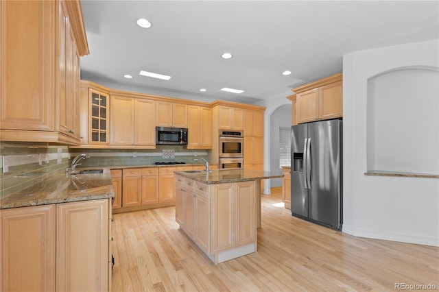1172 S Steele St, Denver, CO 80210 - kitchen with stainless steel appliances, dark stone counters, light brown cabinetry, and recessed lighting