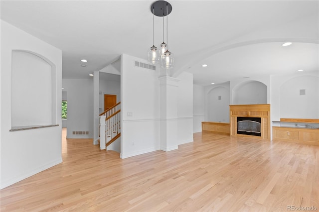 1172 S Steele St, Denver, CO 80210 - unfurnished living room with recessed lighting, light wood-style floors, a tiled fireplace, and stairway