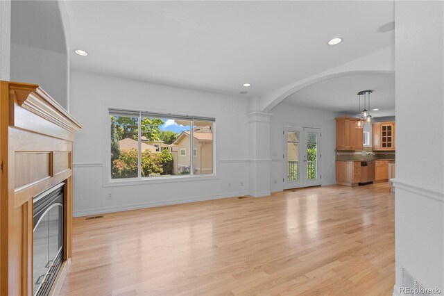 1172 S Steele St, Denver, CO 80210 - unfurnished living room featuring healthy amount of natural light, recessed lighting, arched walkways, and light wood finished floors