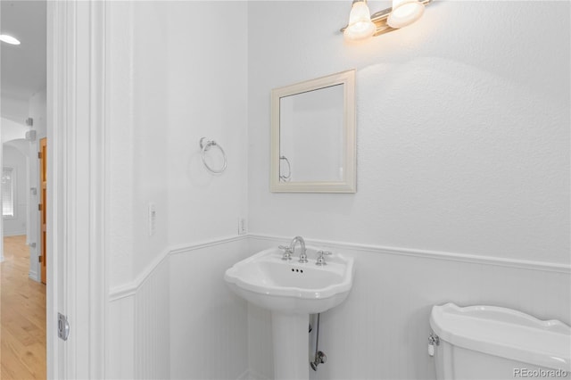 1172 S Steele St, Denver, CO 80210 - bathroom featuring a wainscoted wall and wood finished floors