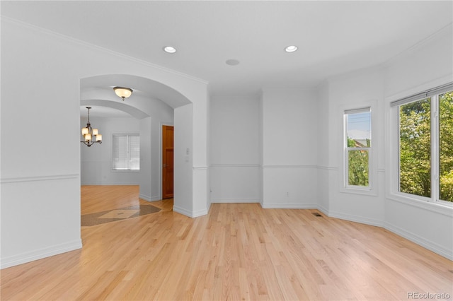 1172 S Steele St, Denver, CO 80210 - empty room featuring light wood finished floors, a chandelier, recessed lighting, arched walkways, and ornamental molding