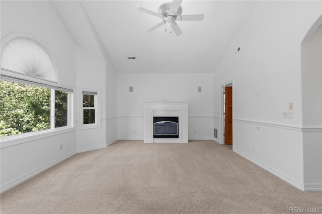 1172 S Steele St, Denver, CO 80210 - unfurnished living room featuring high vaulted ceiling, light colored carpet, a glass covered fireplace, a ceiling fan, and arched walkways