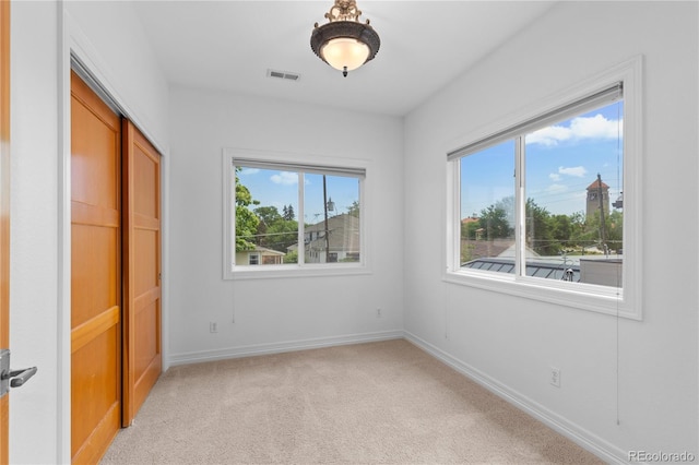 1172 S Steele St, Denver, CO 80210 - unfurnished bedroom with multiple windows, light carpet, and a closet