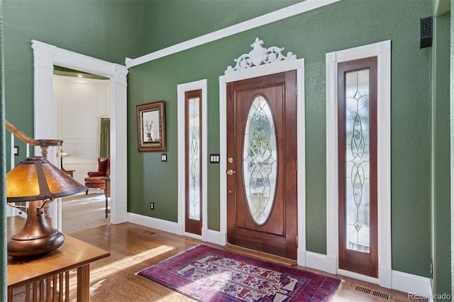 foyer with visible vents, baseboards, and wood finished floors