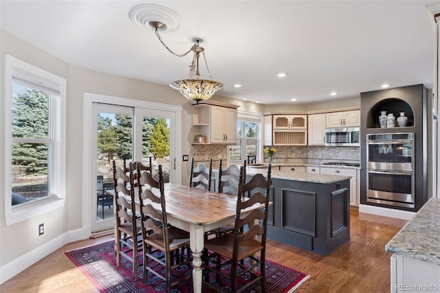 dining room with recessed lighting, baseboards, and wood finished floors