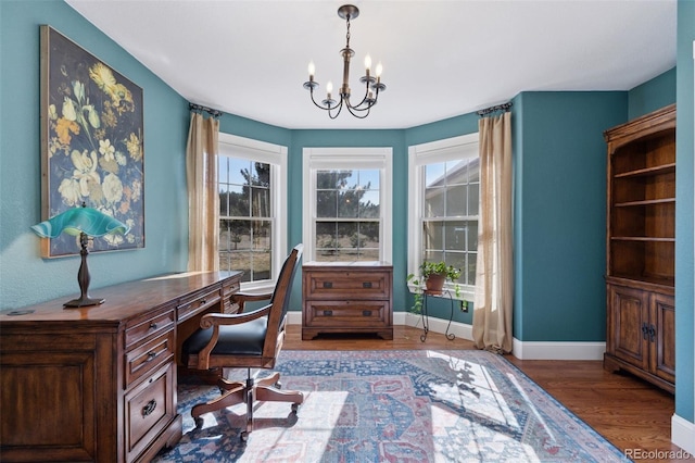 office space with a notable chandelier, wood finished floors, baseboards, and a wealth of natural light