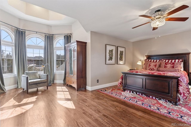 bedroom with baseboards, a ceiling fan, and light wood finished floors