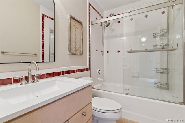 full bath featuring vanity, tile walls, toilet, and enclosed tub / shower combo