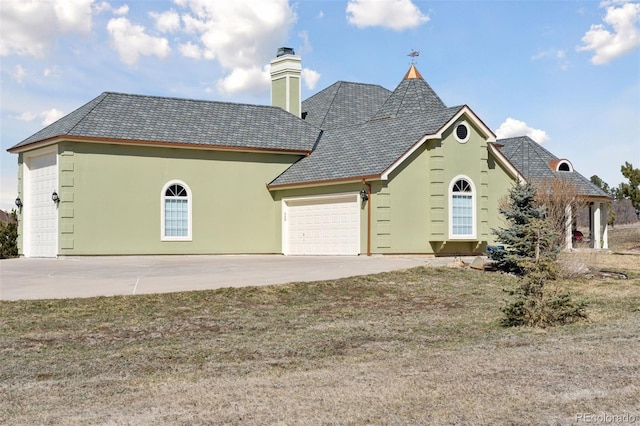 view of front of house featuring stucco siding, driveway, a chimney, and a garage