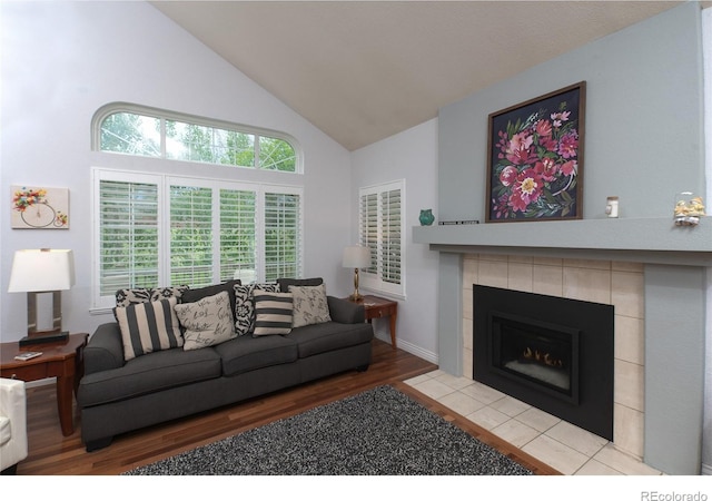 9864 Carmel Ct, Lone Tree, CO 80124 - living room featuring high vaulted ceiling, wood finished floors, and a tile fireplace