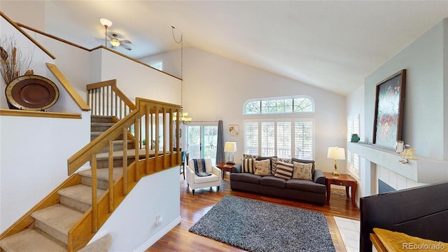 9864 Carmel Ct, Lone Tree, CO 80124 - living room featuring stairs, wood finished floors, high vaulted ceiling, and a chandelier