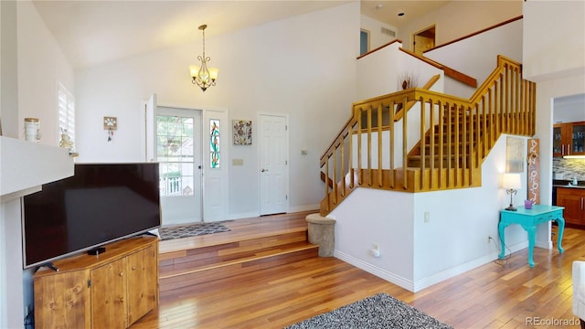 9864 Carmel Ct, Lone Tree, CO 80124 - entryway with hardwood / wood-style floors, stairs, a chandelier, and high vaulted ceiling