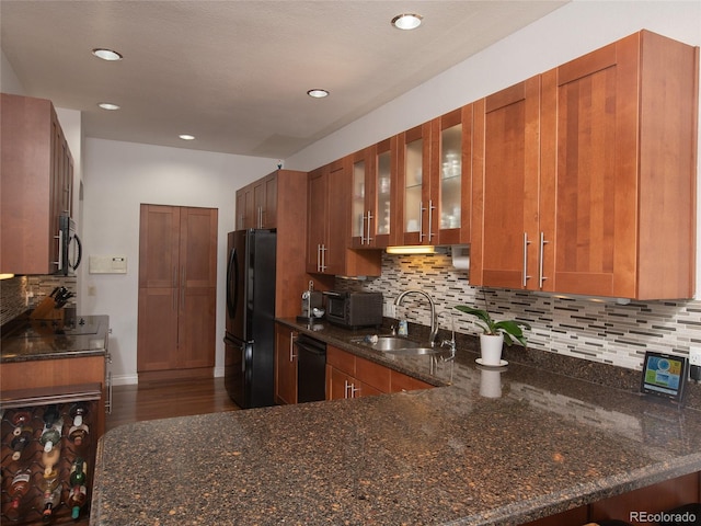 9864 Carmel Ct, Lone Tree, CO 80124 - kitchen featuring black appliances, dark stone countertops, tasteful backsplash, glass insert cabinets, and brown cabinetry