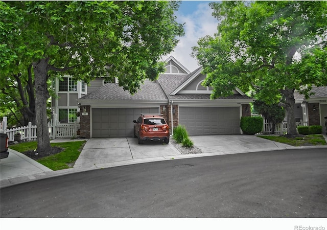 9864 Carmel Ct, Lone Tree, CO 80124 - view of front of house with a garage, driveway, brick siding, and a shingled roof