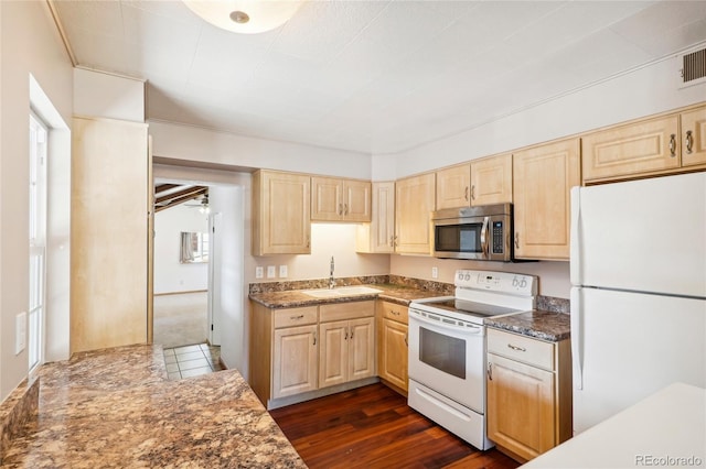 kitchen featuring dark wood-type flooring, sink, white appliances, and a healthy amount of sunlight