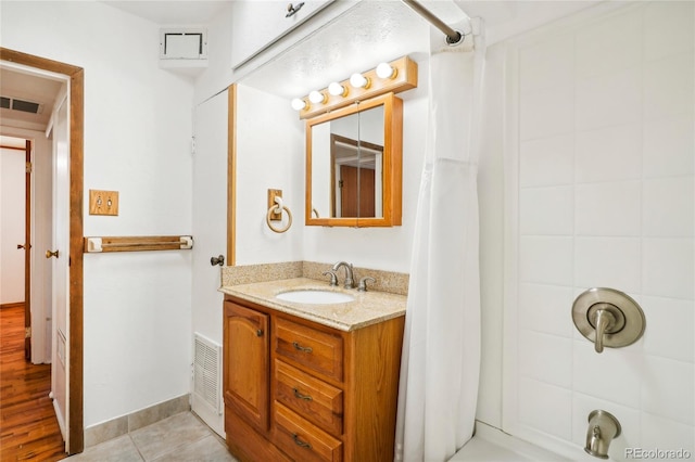 bathroom with wood-type flooring, shower / bath combination with curtain, and vanity