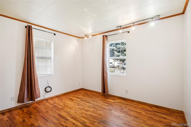 unfurnished room featuring ornamental molding, hardwood / wood-style floors, and rail lighting