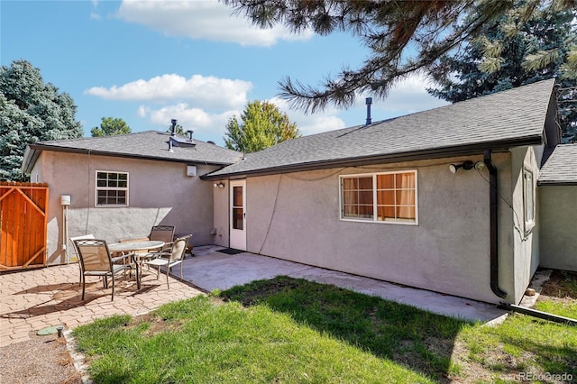 rear view of house featuring a patio and a yard