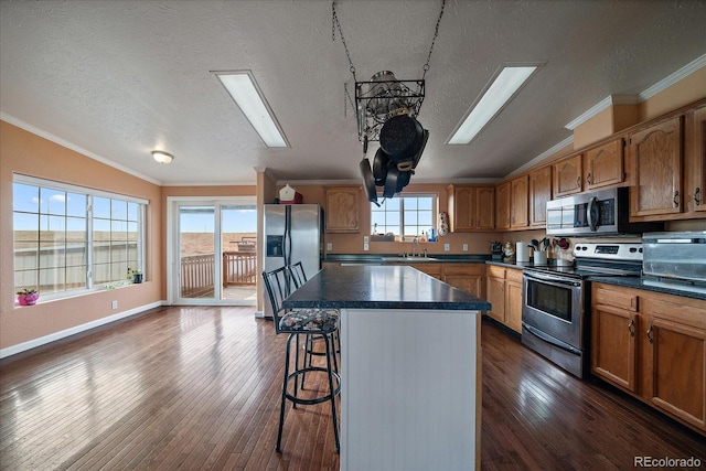 kitchen featuring a textured ceiling, stainless steel appliances, and dark wood-type flooring