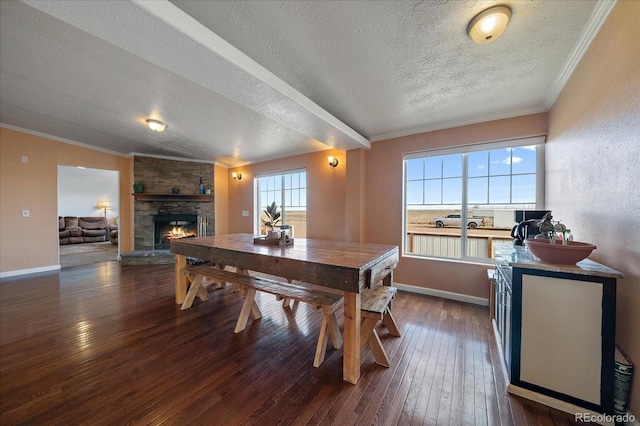 dining space with a fireplace, dark hardwood / wood-style flooring, a textured ceiling, and crown molding