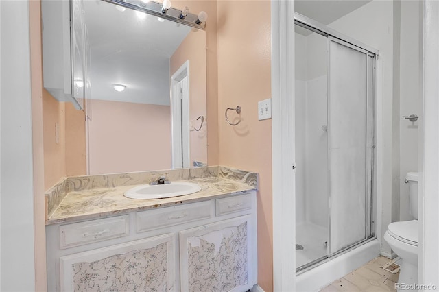 bathroom with tile patterned floors, vanity, toilet, and walk in shower