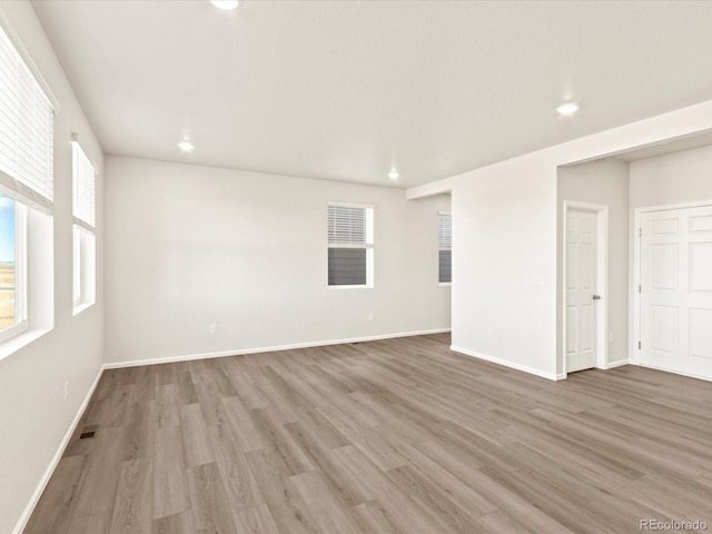 spare room featuring plenty of natural light and hardwood / wood-style floors