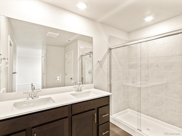 bathroom featuring hardwood / wood-style floors, an enclosed shower, and vanity