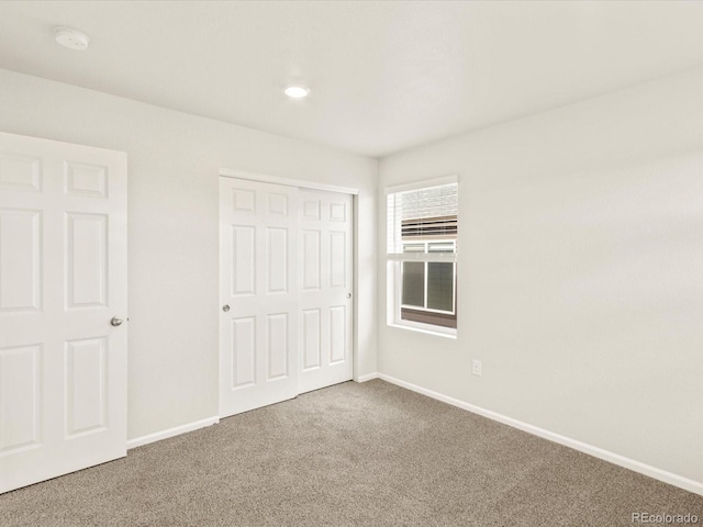 unfurnished bedroom featuring carpet floors and a closet