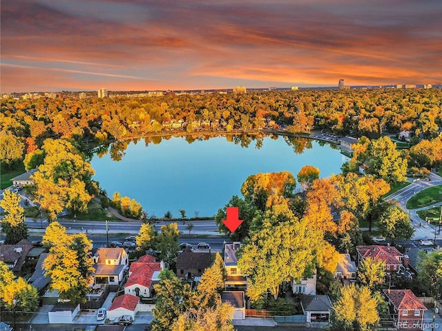 aerial view at dusk featuring a water view